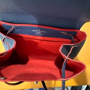 New never used, rare lock me backpack. Navy blue with red interior. Inc. dustbag